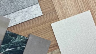 interior material board containing multi pattern of wooden laminateds, grainy quartz stones, grey interior fabric wallpaper, green marble, artificial stone samples. close up or macro view. mood board.