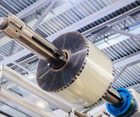 Automatic polyethylene plastic bag production machine with lighting effect. Close-up of the roller of the plastic bag production machine in the light blue scene. product packaging concept